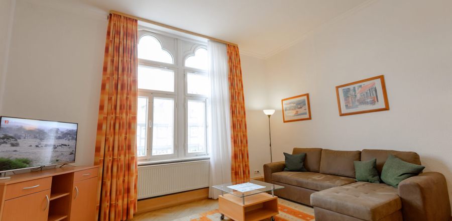 Die Doppelzimmer Comfort bieten etwas mehr Raum und einen Balkon. Auf diesem Bild ist die Einrichtung der Zimmer mit Sitzecke, Schreibtisch und Fernseher zu sehen.