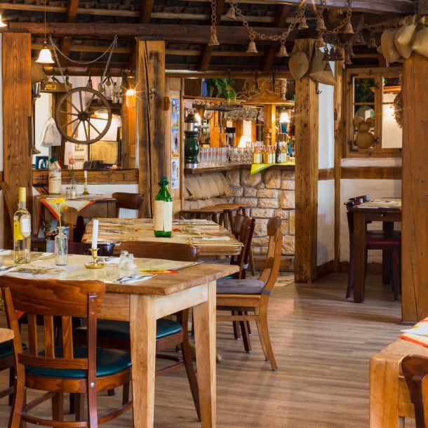 Einige Tische im Kartoffelhaus Wernigerode. Zu sehen ist außerdem die Bar sowie einige der rustikalen Einrichtungsgegenstände.
